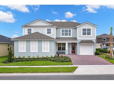 Charming two-story home features a brick driveway, a well-manicured lawn, and a striking red front door at 3029 Ambersweet Pl, Clermont, FL 34711