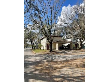 Two-story home with a carport surrounded by mature trees at 3593 Raintree Cir, Lakeland, FL 33803