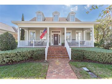 Inviting two-story home featuring a charming front porch, brick walkway, and manicured landscaping at 4268 Ethan Ln, Orlando, FL 32814