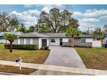 Charming single-story home featuring a well-manicured lawn, stone accents, and a spacious driveway at 605 Hill Ave, Ocoee, FL 34761