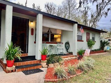 Charming single-story home featuring a covered porch, lovely landscaping, and an inviting entrance at 701 S Delaware Ave, Deland, FL 32720