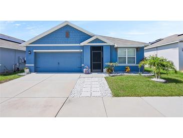 Charming blue single-story home with well-manicured lawn and inviting curb appeal at 756 Kindred Ln, Auburndale, FL 33823