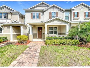 Attractive two-story townhouse with inviting front porch, brick walkway and manicured lawn at 13730 Bravante Aly, Windermere, FL 34786