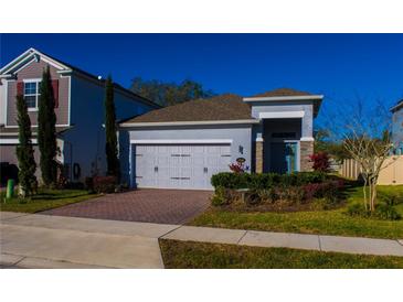 Charming single-Gathering home featuring a brick driveway, two-car garage, and meticulously maintained landscaping at 1740 Deans Crossing Ln, Orlando, FL 32825