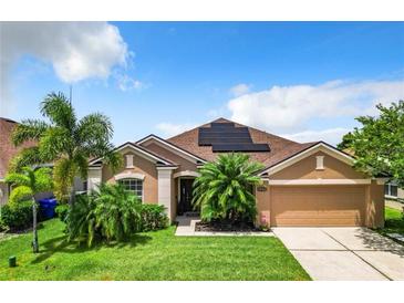 Charming single-story home with well-manicured lawn, palm trees, and a two-car garage at 2281 The Oaks Blvd, Kissimmee, FL 34746