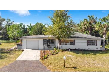 Charming single-story home with a well-manicured lawn, fresh landscaping, and an attached garage at 33 Sunset Dr, Debary, FL 32713