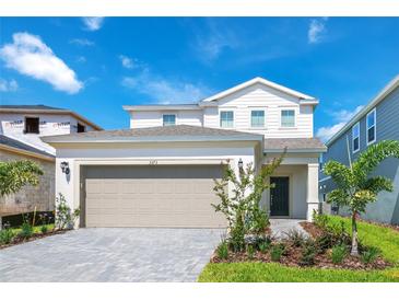 Charming two-story home with a two-car garage and manicured front yard landscaping at 3373 Lilac Way, Davenport, FL 33897