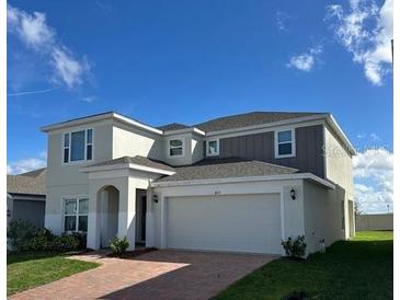 Two-story home featuring a two-car garage, neutral colors, and a well-manicured lawn at 4229 Deleon St, Haines City, FL 33844