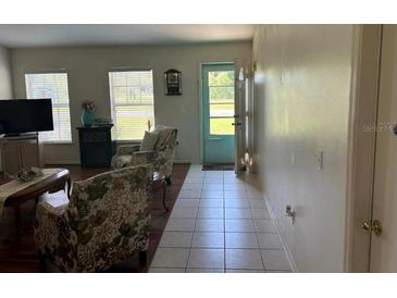 Inviting living room featuring tile flooring and comfortable seating, flooded with natural light from large windows at 6743 Sw 129Th St, Ocala, FL 34473