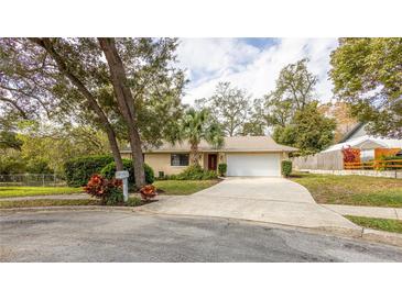 Charming one-story home featuring a well-manicured lawn, mature trees, and a two-car garage at 690 Shady Ct, Altamonte Springs, FL 32701