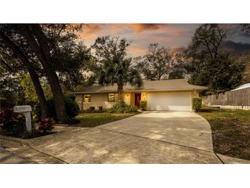 Charming single-story home with a well-manicured front yard, palm tree, and a two-car garage at 690 Shady Ct, Altamonte Springs, FL 32701