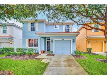 Charming two-story home with a well-manicured lawn and a driveway leading to a one-car garage at 8900 Candy Palm Rd, Kissimmee, FL 34747