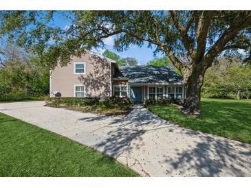 Charming two-story home featuring mature landscaping, a spacious driveway, and a welcoming front entrance at 1606 Wildcat Ct, Winter Springs, FL 32708