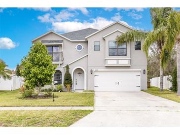 Charming two-story home featuring a well-manicured lawn, attached two car garage and mature trees at 2831 Orange Haven Way, Kissimmee, FL 34746