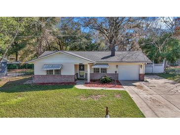 Charming single-story home with a well-manicured lawn, brick accents, and an attached one car garage at 2833 Ne 18Th Ct, Ocala, FL 34470
