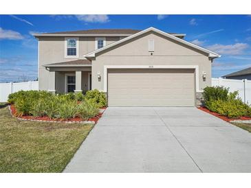 Charming two-story home with a two-car garage, landscaped yard, and a welcoming front porch at 365 Quarry Rock Cir, Kissimmee, FL 34758