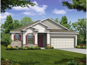 Charming single-story home featuring stone accents, a well-manicured lawn, and a two-car garage at 6598 Lullaby Way, Mascotte, FL 34753