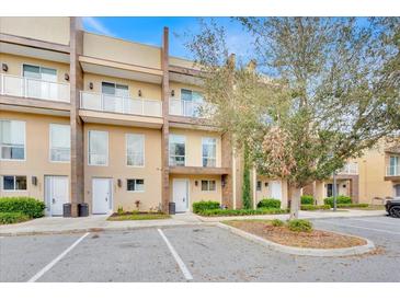 Charming multi-story townhome featuring a private balcony and well-manicured landscaping at 7663 Recife Dr, Kissimmee, FL 34747