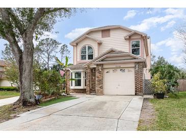 Charming two-story home with a brick-accented facade and well-maintained front yard, offering a welcoming curb appeal at 12100 Calaboose Ct, Orlando, FL 32828