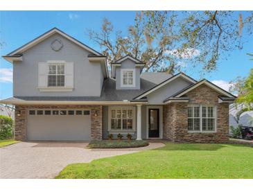 Charming two-story home with stone accents, attached two car garage, and well manicured lawn at 1230 Mercedes Pl, Orlando, FL 32804