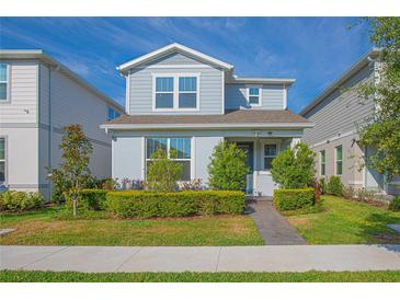 Charming two-story home with manicured lawn and pathway to the front door under a clear blue sky at 14250 Lanikai Beach Dr, Orlando, FL 32827