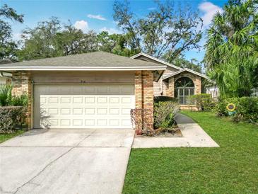 Charming home featuring a brick facade, a two-car garage, and well-maintained landscaping at 216 Springside Rd, Longwood, FL 32779