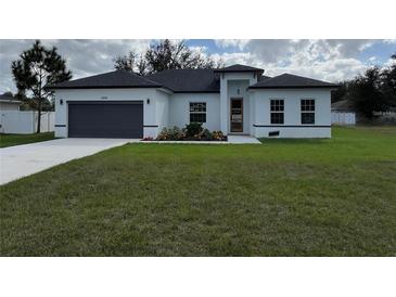 Charming single-story home featuring a well-manicured lawn and a two-car garage at 2662 Sw 152Nd Ln, Ocala, FL 34473