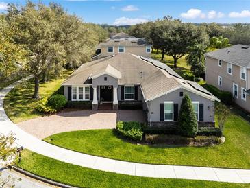 Charming single-story home with brick driveway, manicured lawn and mature trees at 2856 Park Meadow Dr, Apopka, FL 32703