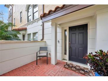 Charming front entrance featuring a brick-paved porch, black door, and manicured landscaping at 3909 Messina Dr, Lake Mary, FL 32746