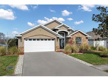 Charming single Gathering home featuring stone accents, a two-car garage and beautiful landscaping at 4057 Sunny Day Way, Kissimmee, FL 34744