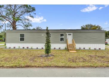 Charming single-story home with new light-green siding, white trim, and a well-manicured front lawn at 5227 Orange Ave, Port Orange, FL 32127