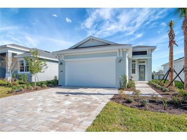 Charming single Gathering home with a well-manicured lawn and a brick driveway at 889 Megano Blvd, Deland, FL 32724