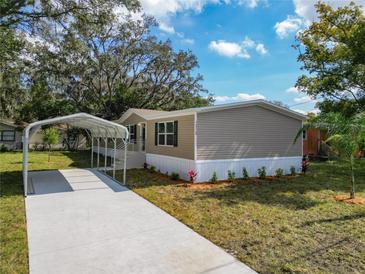 Charming single-story home showcasing a carport, landscaped front yard, and light beige vinyl siding at 1510 Oak Ln, Casselberry, FL 32707