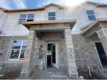 Image showing the exterior of a townhome in construction, with block and Tyvek wrap at 15352 Burgtheater Dr, Winter Garden, FL 34787