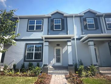 Charming two-story townhome featuring light blue siding, dark accents, and a well-maintained front yard at 15352 Burgtheater Dr, Winter Garden, FL 34787