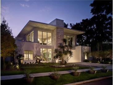 Modern two-story home with manicured lawn and beautiful landscaping at twilight at 229 Alexander Pl, Winter Park, FL 32789