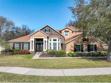 Charming two-story home with a beautifully landscaped front yard and classic architectural details at 2805 Ponkan Meadow Dr, Apopka, FL 32712