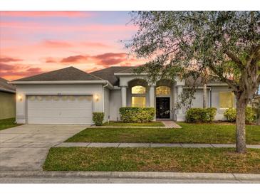 Charming one-story home with a manicured lawn, arched entryway, and two-car garage at 2819 Boating Blvd, Kissimmee, FL 34746