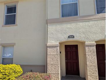 Inviting townhome entrance featuring a classic red door and address number at 2836 Club Cortile Cir, Kissimmee, FL 34746