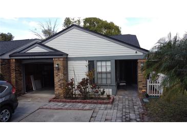 Charming single-story home with brick accents, white siding, and an attached garage at 5323 Alcom Dr, Orlando, FL 32812