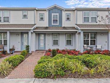 Charming townhome showcasing manicured landscaping, a brick pathway, and a cozy front seating area at 10426 Folly Beach Rd, Orlando, FL 32827