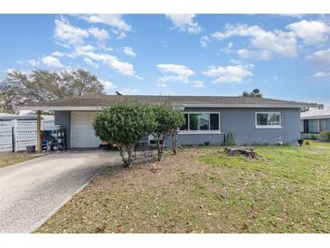 Charming single-story home with a well-manicured lawn and an attached garage on a bright, sunny day at 1503 Wisconsin Ave, St Cloud, FL 34769