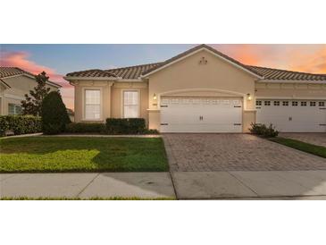 Charming single-story home featuring a tile roof, brick driveway, and well-manicured lawn at 2865 Eastham Ln, Kissimmee, FL 34741