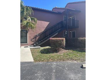 Exterior of condo with stairs leading to the second story entrance and tidy landscaping at 631 Grenadine Ct # 631, Winter Park, FL 32792