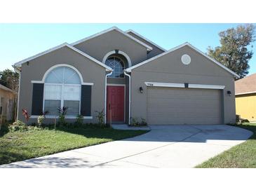 Charming single-Gathering home featuring a red front door, well-manicured lawn, and a two-car garage at 7756 Beridale Ct, Orlando, FL 32818