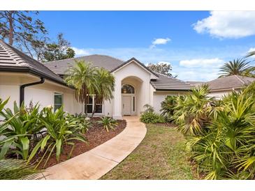 Charming home exterior with lush landscaping and a welcoming entryway, and tile roof at 9308 Thurloe Pl, Orlando, FL 32827