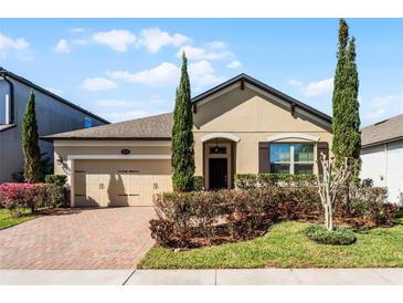 Charming single Gathering home featuring a brick driveway, two-car garage, and well manicured landscaping at 1112 Narcoossee Del Sol Blvd, St Cloud, FL 34771