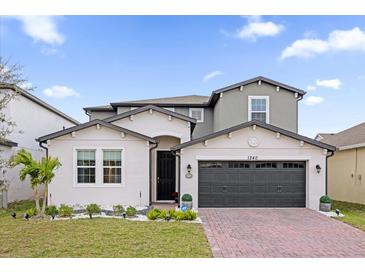 Charming two-story home featuring a brick driveway and landscaped front yard at 1240 Lone Palm Way, St Cloud, FL 34771