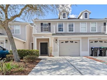 Charming townhome with a one-car garage, front balcony, well-maintained landscaping, and inviting curb appeal at 1270 Falling Star Ln, Orlando, FL 32828