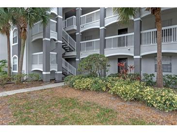 Condo exterior showing stairs, well-maintained landscaping, and palm trees at 13929 Fairway Island Dr # 813, Orlando, FL 32837